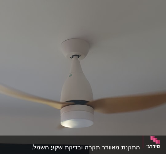 מאוורר תקרה עם תאורה מותקן על תקרה לבנה